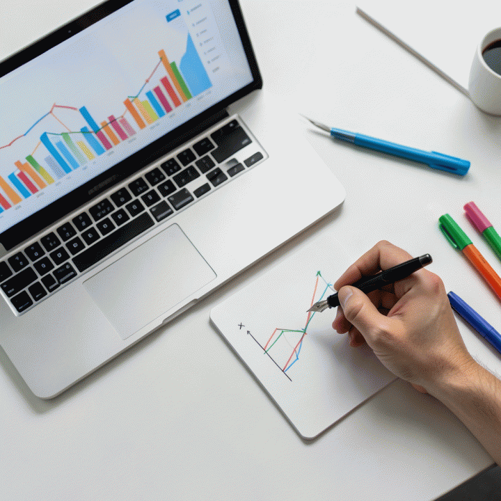 Pandangan atas berbagai alat perencanaan keuangan (laptop dengan grafik abstrak dan buku catatan) yang digunakan untuk menentukan harga jual optimal.