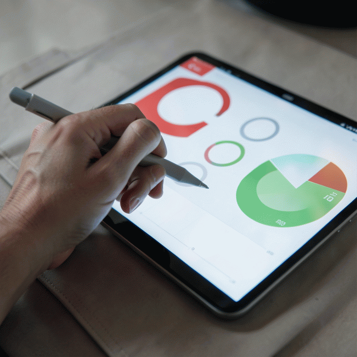 Tangan yang sedang menggunakan stylus pada tablet, menampilkan dashboard keuangan abstrak yang menunjukkan visualisasi pengelolaan utang yang terorganisir dan terukur.