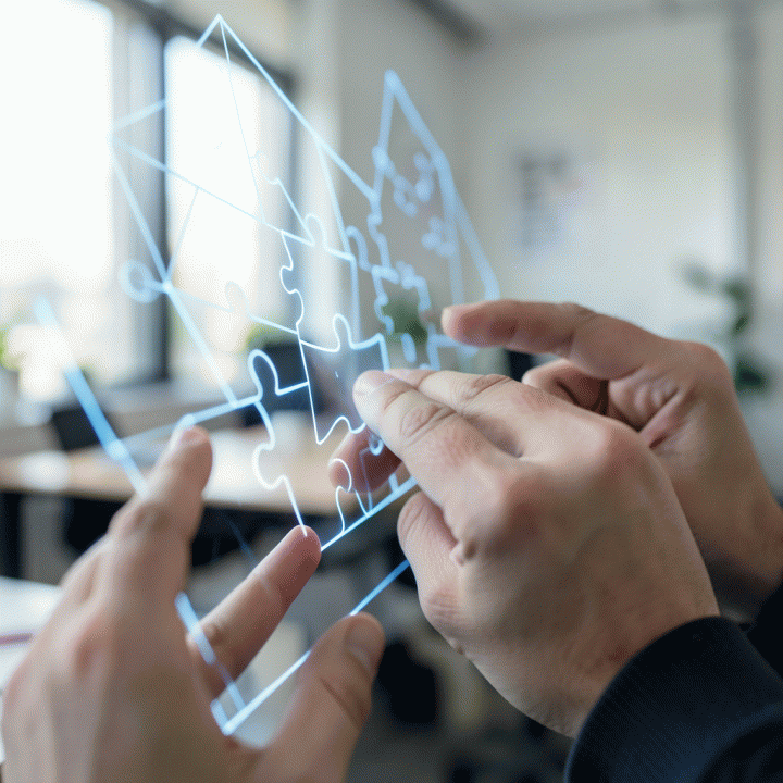 Tangan yang berinteraksi dengan proyeksi digital berisi pola geometris dan puzzle yang terhubung, melambangkan pemecahan masalah logika.